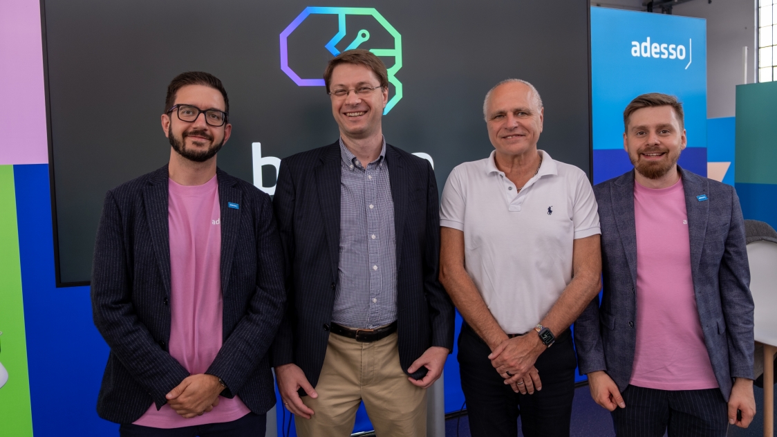 Teamfoto von Br.AI.n, adesso und evia auf dem Adesso Digital Day 2025 vor Br.AI.n-Logo