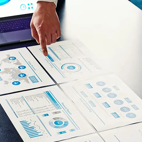 Softwareentwickler arbeitet an einem Laptop, umgeben von mehreren Bildschirmen, auf denen Code und Software-Entwicklungsumgebungen angezeigt werden.