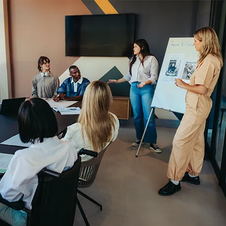 Softwareentwickler arbeitet an einem Laptop, umgeben von mehreren Bildschirmen, auf denen Code und Software-Entwicklungsumgebungen angezeigt werden.